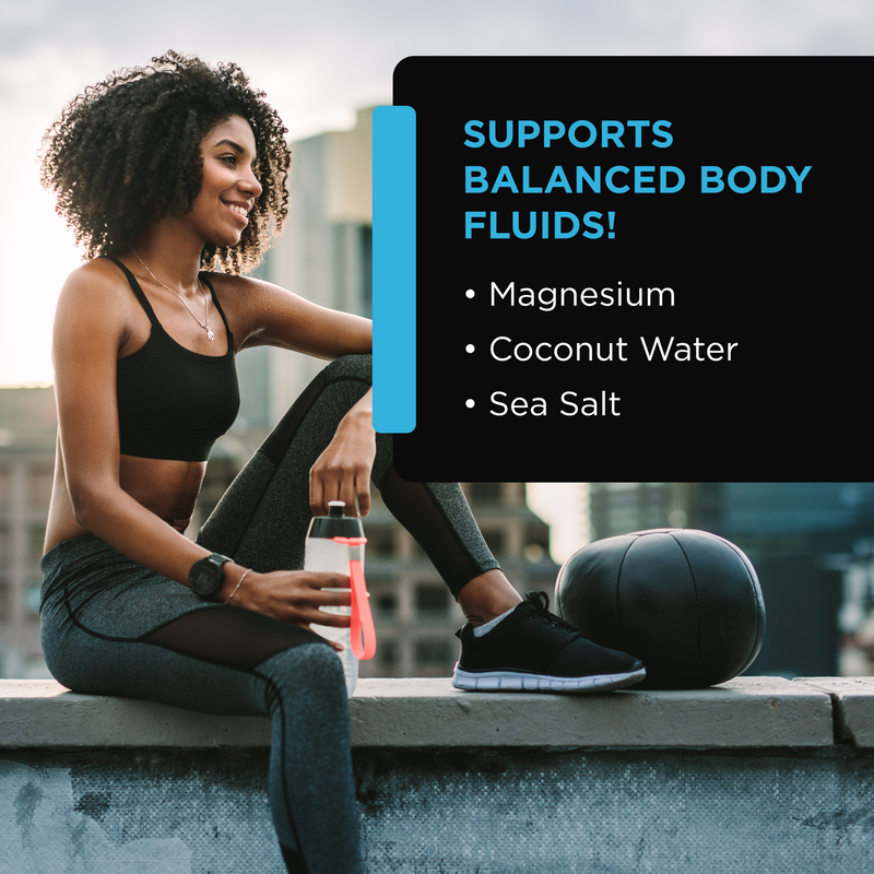 Fitness woman resting with water bottle and medicine ball after workout outdoors with text about balanced body fluids, magnesium, coconut water, sea salt